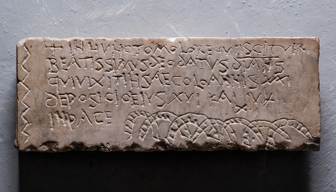 Fr&uuml;hchristlicher Grabstein f&uuml;r einen Diakon namens Deodatus. Schriftmerkmale, Sprachform und Ziermotive sprechen f&uuml;r eine Datierung in das fr&uuml;he 7. Jahrhundert (Bodenfund nahe der Gemeinde Kobern-Gondorf, Lkr. Mayen-Koblenz, heute LVR-LandesMuseum Bonn). 