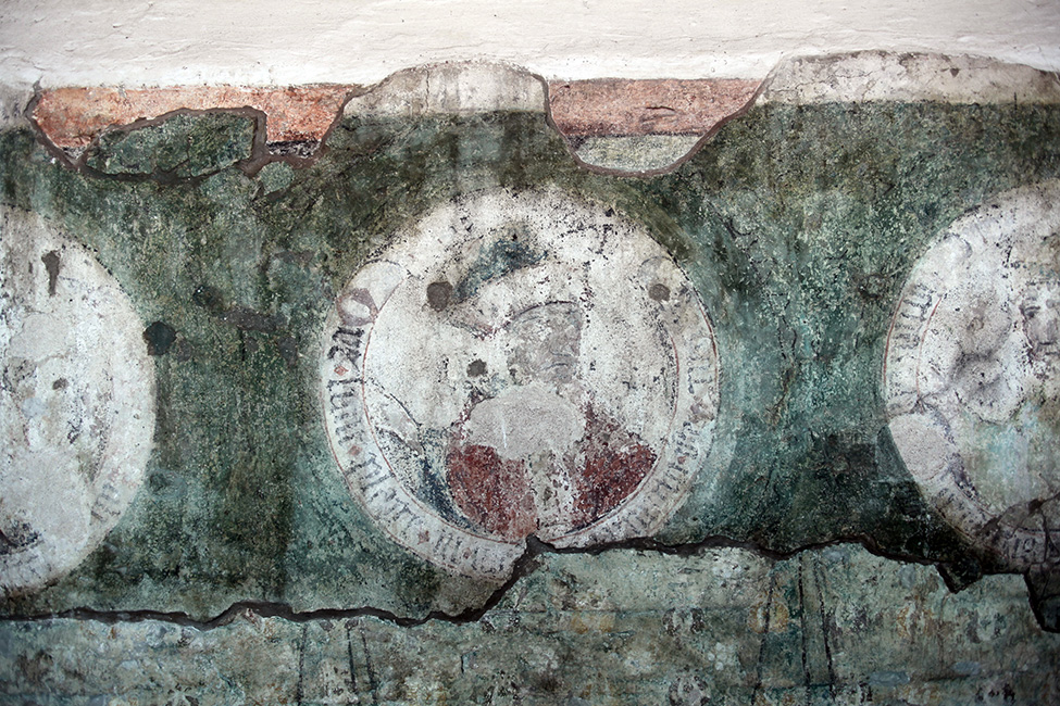 M&auml;nnliches Brustbild mit verblasster Umschrift in einem Medaillon (15. Jh.), das zu den Resten von Wandmalereien in den Klausurgeb&auml;uden des St. Johannis Franziskanerklosters in Stralsund geh&ouml;rt. Der schlechte Erhaltungszustand der mehrschichtig sich &uuml;berlagernden Wandmalereien erm&ouml;glicht keine inhaltliche Bestimmung der fragmentarischen Bilddarstellung und Inschriftenreste.