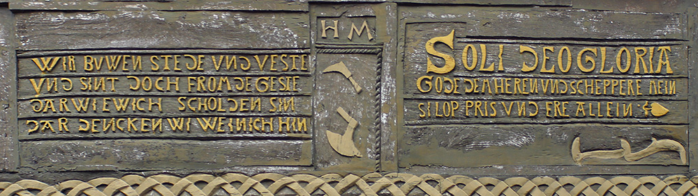 Br&uuml;stungstafeln am ehem. Haus der Schuhmachergilde (1540?) in Alfeld, Lkr. Hildesheim. Sinnspr&uuml;che, die &uuml;ber das Bauen reflektieren oder Gotteslob enthalten, sind ein typischer Bestandteil der Fassadengestaltung prachtvoller Fachwerkh&auml;user.