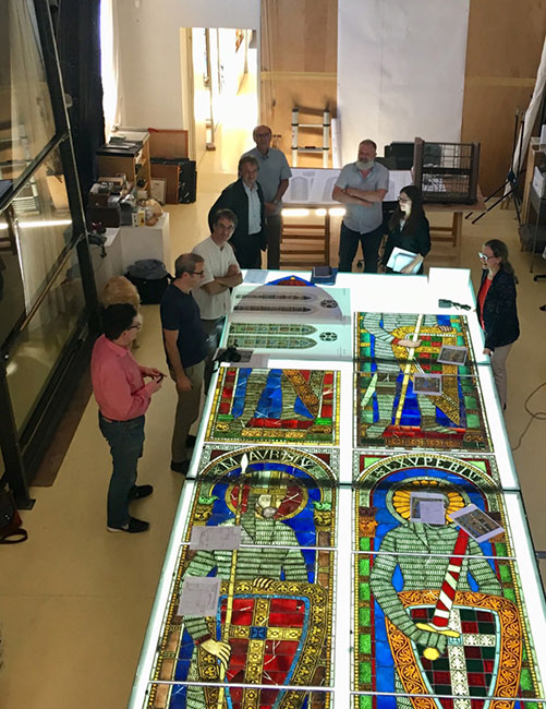 Forschende untersuchen die Glasscheiben mit den Malereien