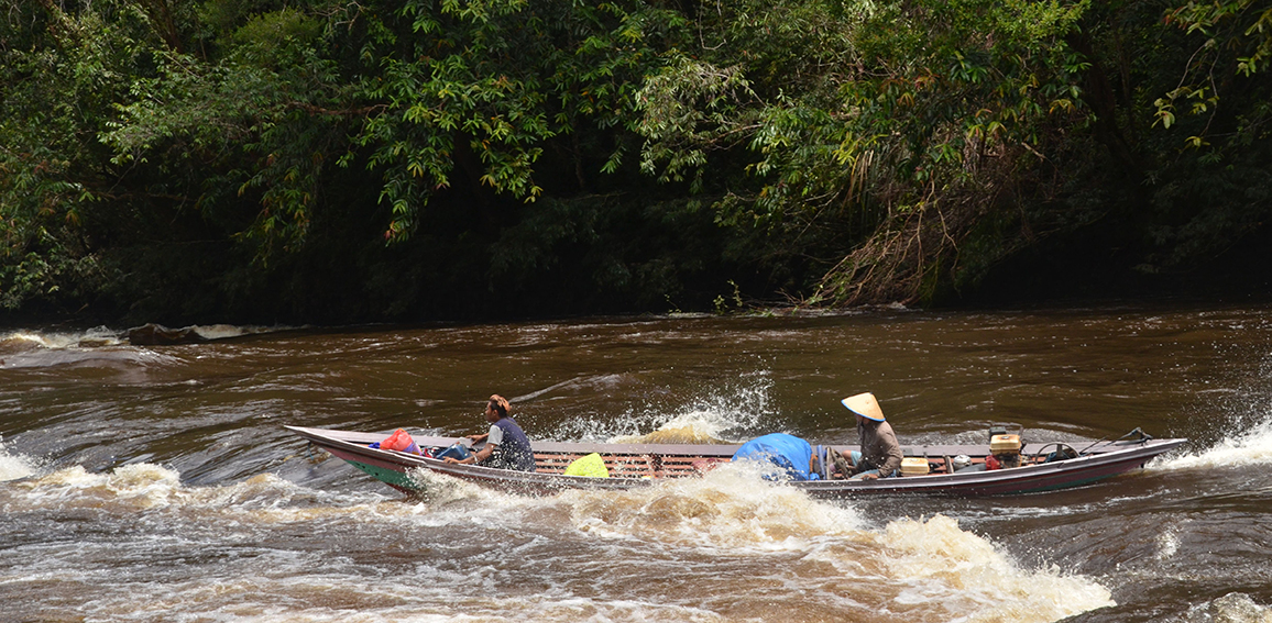 zwei Personen fahren mit einem Boot auf einem Fluss 