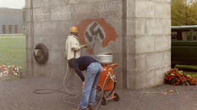Entfernung eines Hakenkreuzes, das Unbekannte auf das Internationale Mahnmal der KZ-Gedenkstätte Neuengamme gesprüht hatten, 11. Mai 1986  Foto: unbekannt, Archiv der KZ-Gedenkstätte Neuengamme, F 1986-7351 
