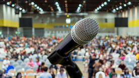 Mikrofron vor Veranstaltungshalle; © Adobe Stock