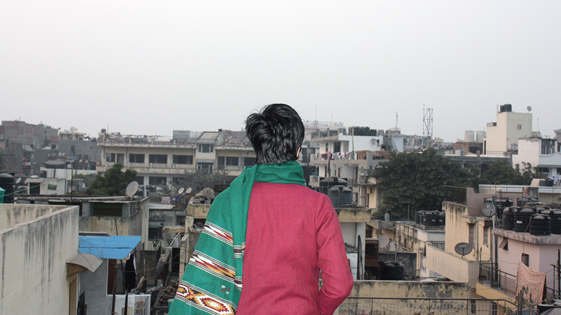 Frau steht vor &auml;rmlich wirkenden H&auml;usern; &copy; Lucie Bernroider 