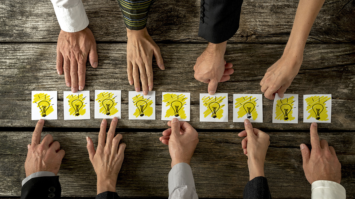 9 H&auml;nde greifen nach Schildern mit einer Gl&uuml;hbirne; &copy; Fotolia/Gaj Rudolf
