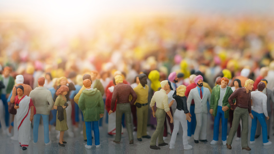 Viele Spielfiguren die eine bunde Menschenmenge symbolisieren